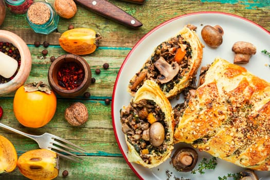Piece closed homemade savory tart pie with mushrooms and persimmon