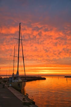 Sailing ship in the harbor of lake Vaettern at sunset. Lighthouse in the background. Landscape shot from Scandinavia