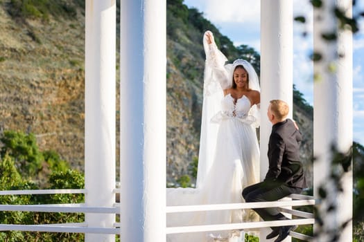 Newlyweds on a walk in the gazebo look at each other happily