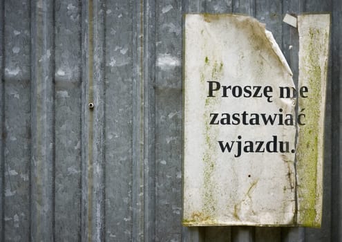 Sign with the inscription proszę nie zastawiać wjazdu on the door of a construction container at a construction site in Poland white copy space on left side. Translation: please do not block the entrance