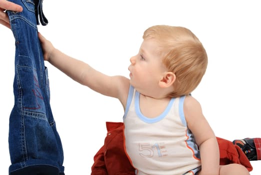 The beautiful little boy tries on clothes