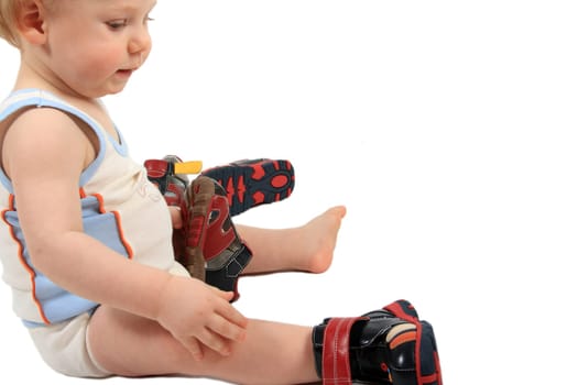 The beautiful little boy tries on footwear