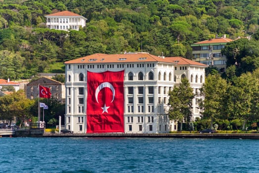 Traditional old waterside mansion, with huge Turkish Flag, suited in the Asian side of Bosphorus Strait, in Uskudar neighborhood, Istanbul, Turkey