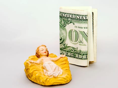 Commercialism vs Christmas a bill beside the Christ Child.