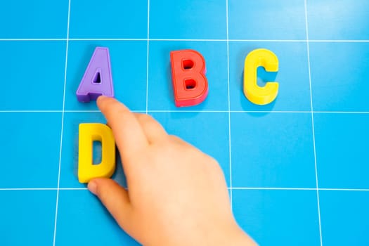 child learning the ABC's. The focus is on the letter B