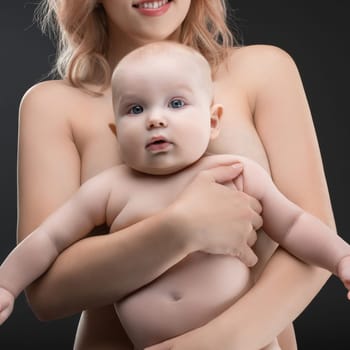 A mother gently holds her baby close, both displaying serene expressions in a soft light. Their affection creates a warm atmosphere.