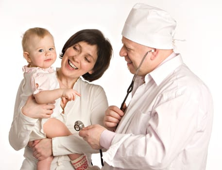 Smiling mum with the little girl on hands stands near to the doctor in white dressing gown on a white background.