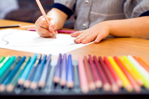 little girl playing with colors. The focus is on the hand laying on the paper