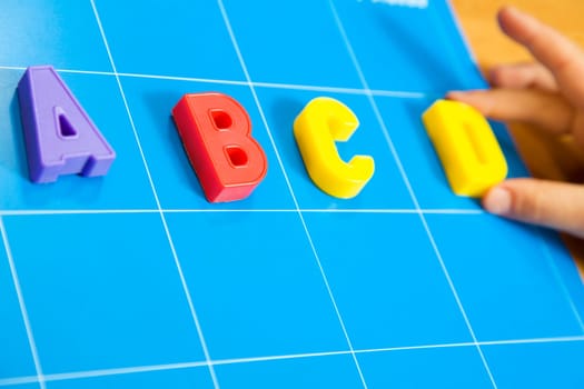 child learning the ABC's. The focus is on the letter B