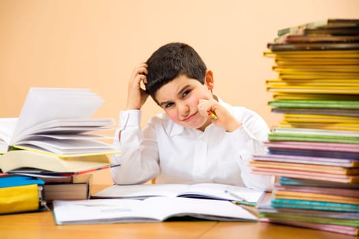 little boy has troubles with homeworks and is scratching his head