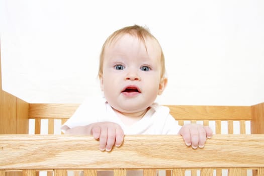 Little Baby holding onto side of crib