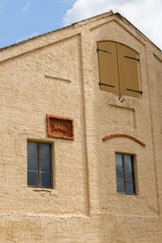 Yellow-coated facade of a stable with cattle relief