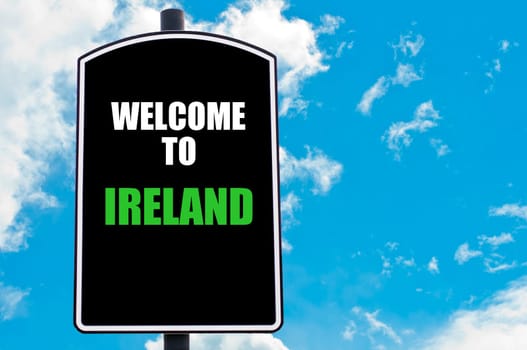 Black road sign with greeting message WELCOME TO IRELAND isolated over clear blue sky background with available copy space. Travel destination concept  image