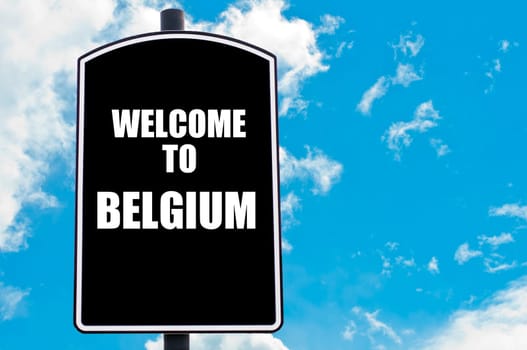Black road sign with greeting message WELCOME TO BELGIUM isolated over clear blue sky background with available copy space. Travel destination concept  image