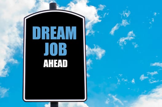DREAM JOB AHEAD motivational quote written on road sign isolated over clear blue sky background with available copy space. Concept  image