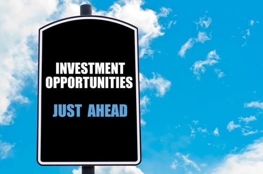 INVESTMENT OPPORTUNITIES JUST AHEAD motivational quote written on road sign isolated over clear blue sky background with available copy space. Concept  image