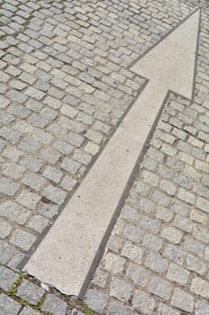 Arrow on a road with cobblestones