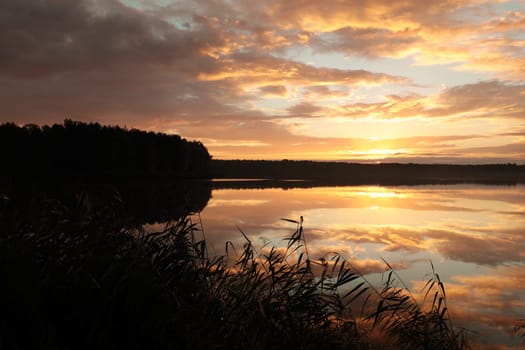 Sunrise over the lake on a cloudy autumn day