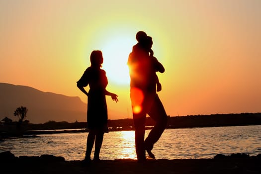 silhouette of a happy family of three on the beach
