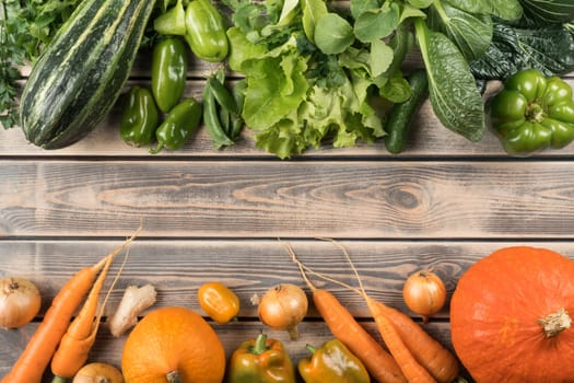 Horizontal rows of green and orange fresh vegetables on wooden table, top view. Sorting products by color. Nitrate free food or healthy diet concept. Objects layout. Planking. Cooking ingredients.