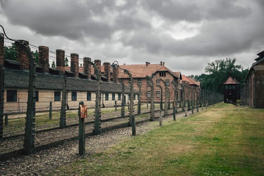 Barracks for prisoners behind barbed wire fence in Auschwitz Nazi concentration camp Poland