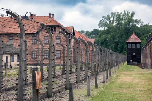Barracks for prisoners behind barbed wire fence in Auschwitz Nazi concentration camp Poland