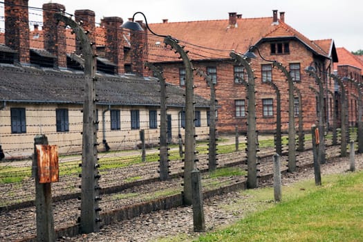 Barracks for prisoners behind barbed wire fence in Auschwitz Nazi concentration camp Poland