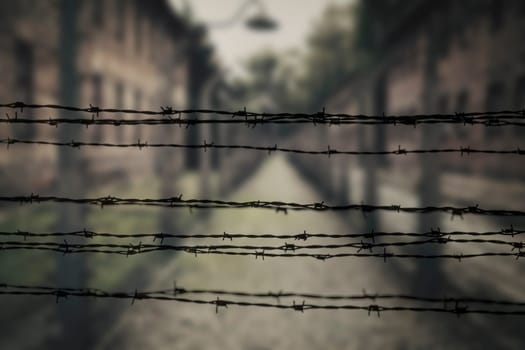 Barracks for prisoners behind barbed wire fence in Auschwitz Nazi concentration camp Poland
