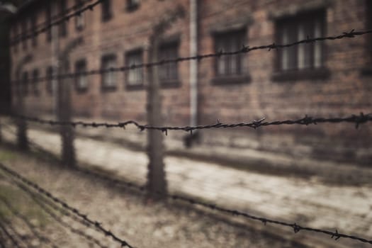 Barracks for prisoners behind barbed wire fence in Auschwitz Nazi concentration camp Poland