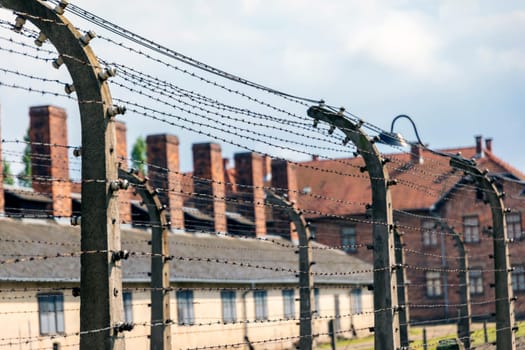 Barracks for prisoners behind barbed wire fence in Auschwitz Nazi concentration camp Poland