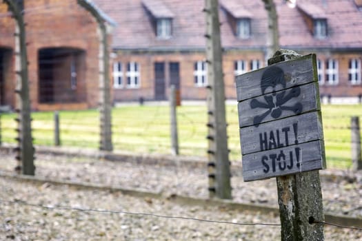 Barracks for prisoners behind barbed wire fence in Auschwitz Nazi concentration camp Poland
