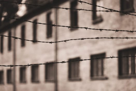 Barracks for prisoners behind barbed wire fence in Auschwitz Nazi concentration camp Poland