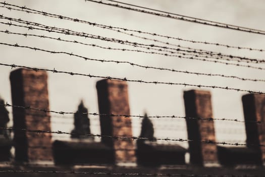 Barracks for prisoners behind barbed wire fence in Auschwitz Nazi concentration camp Poland