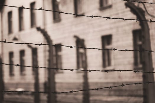 Barracks for prisoners behind barbed wire fence in Auschwitz Nazi concentration camp Poland