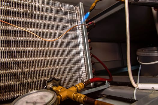 Soldering copper pipes of the refrigerator with oxygen welding. Oxygen welding. Connection of copper pipes. Refrigerator repair. Repair of air conditioners. Working industrial tool.