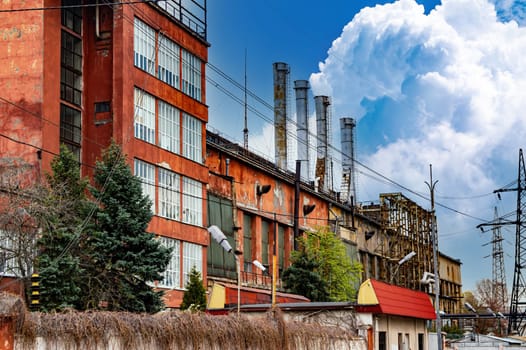 Industrial plant with chimneys against the blue sky. Industrial enterprise. Chimneys of the plant. Environmental protection. Ecology. Place of work. White smoke. Business.