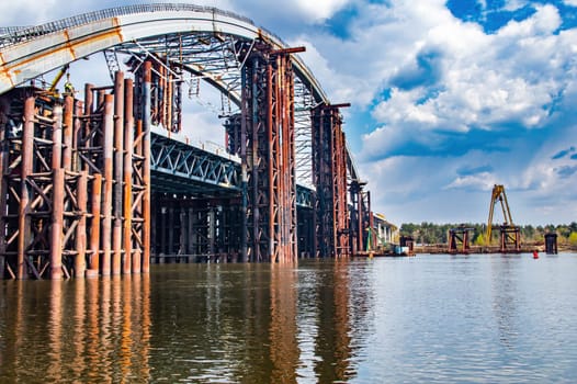 Reinforced concrete structure of the bridge under construction. Bridge over the Dnieper River in Kiev. Engineering structure. Building construction. Water crossing. Industry. Ukraine.