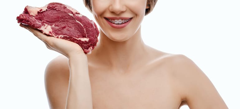 Unrecognizable happy woman holds fresh beef steak in hand isolated on white background