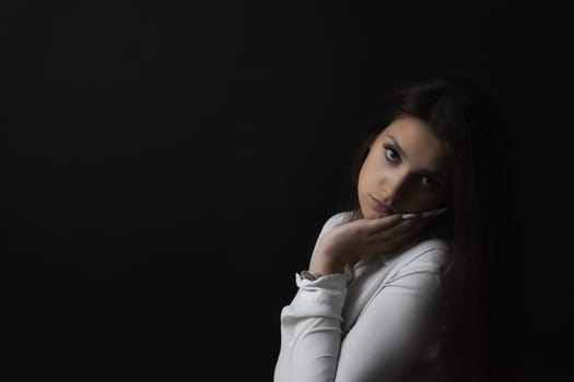 Sad girl in low key portrait. Horizontally.