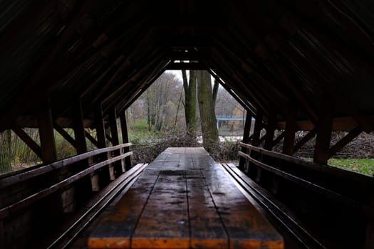 Panorama frame Eating area inside the pavilion of a park with view of trees and cloudy sky.