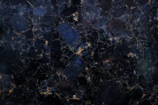 black marble texture with blue and yellow blotches abstract background pattern.