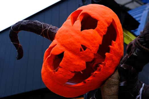 Helloween Pumpkin Head in orange paint with long tail.