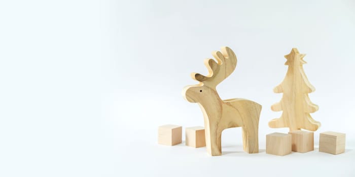 Christmas winter festive ornament. Wooden reindeer, pine tree and gift boxes decoration on white background. Christmas holiday party decoration. Minimal holiday greeting season. Panoramic banner.