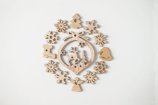 Christmas winter festive ornament. Wooden Christmas decoration on white background. Christmas holiday party decoration. Minimal holiday greeting season. Selective focus.
