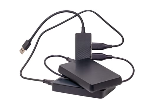 Two large capacity external hard drives connected via USB cable to a 4-port USB distributor isolated on white background. Clipping path. Connect to laptop for backing up files