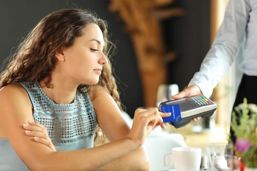Customer is paying with a credit card and dataphone in a restaurant