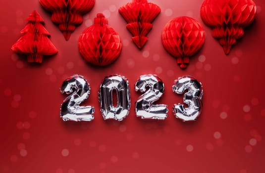 Christmas or New Year background. Red burgundy color flat lay with decorations and silver shiny 2023 baloon numbers. Copy space area for advertising. Simple minimalistic greeting card mockup