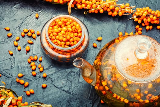 Salubrious autumn drink, tea with fresh sea buckthorn berries