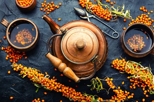 Salubrious autumn drink, tea with fresh sea buckthorn berries