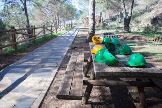 Mine The Jayona, declared natural monument. Fuente del Arco, Badajoz, Spain. Helmets over wooden table